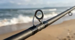 Close-up view of stainless steel line guides on a budget surf rod under $150 designed for saltwater fishing