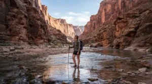 An adventurer in breathable waders for warm weather fishing exploring a wide desert canyon river.