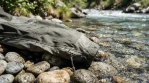 Close-up of lightweight breathable waders for warm weather fishing featuring advanced moisture-wicking fabric on a riverbank.