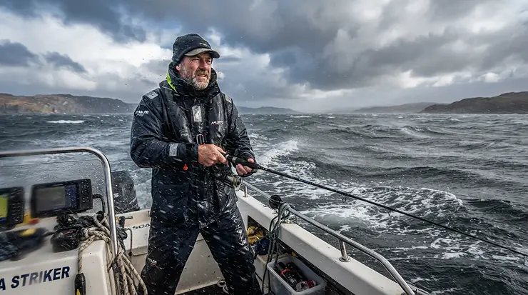 Advanced storm safety features integrated into heavy-duty rain gear for kayak fishing on open bay waters.